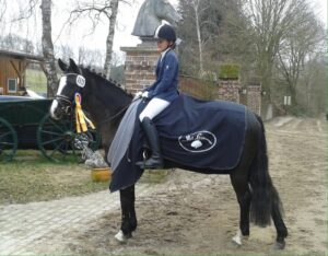 Rebecca Kraus und Cookie mit Paradedecke ud goldener Schleife in Sieversdorf